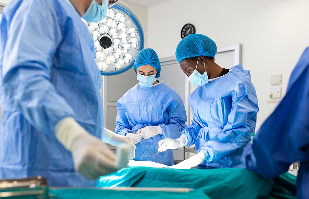 A team of surgeons in uniform performs an operation on a patient at a cardiac surgery clinic